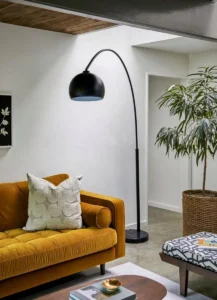 overhead Floor lamp with long bent stand black beside the couch